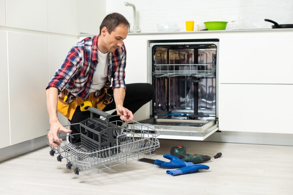 worker repairing dishwasher